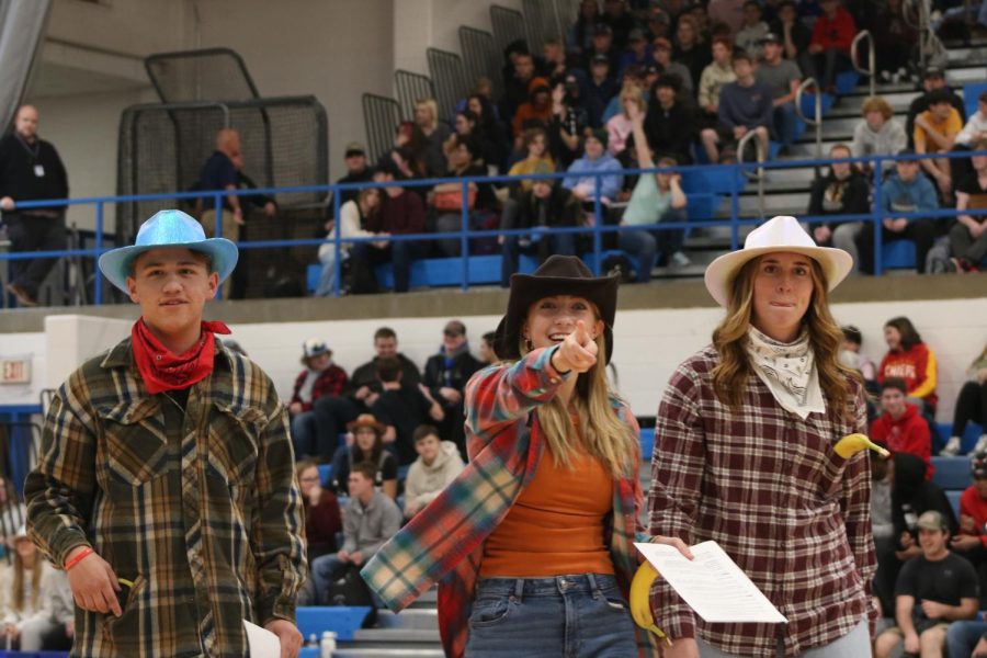 Winter pep assembly emcees, Austin Gober (left), Madeline Grimes (middle), and Emily Bruckerhoff (right), get students excited for the upcoming winter sports season. We have fun music to go with [the assembly] that way people can really remember the sports, Brickel said.
