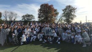 The WHS student section poses for a picture after the WHS boys soccer team win against Harrisonville Nov. 10. "It's super exciting since it's my last year,” senior Bria Hasenjaeger said. “All these kids coming to support the soccer team makes this one of the most memorable moments of high school.” The theme for the game was white out because the boys soccer team was wearing their white jerseys.