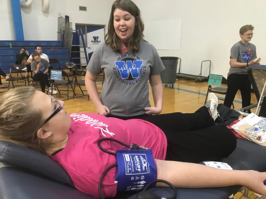 Sophomore Abbie Vollmer talks to senior Gina Luko while she donates blood. “The students get to see what’s going on,” science teacher Krista Williams said. “They have the opportunity to help their future patients or people in the real world.” Students were able to watch Mercy Hospital’s medical professionals take blood while interacting with blood donors.