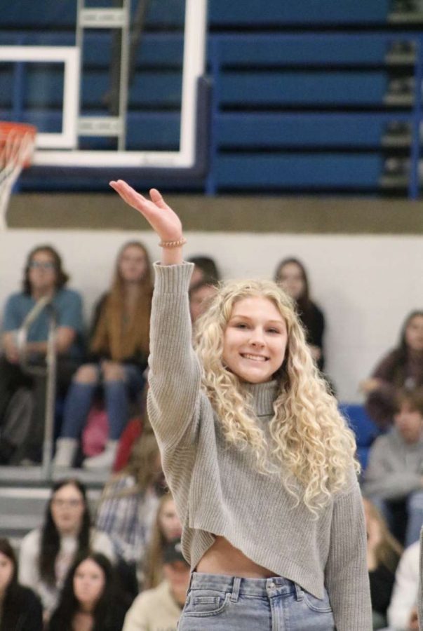 Senior Lindsey Titter waves to the crowd as she is being acknowledged. Lindsey is a senior on the varsity cheer team at WHS.